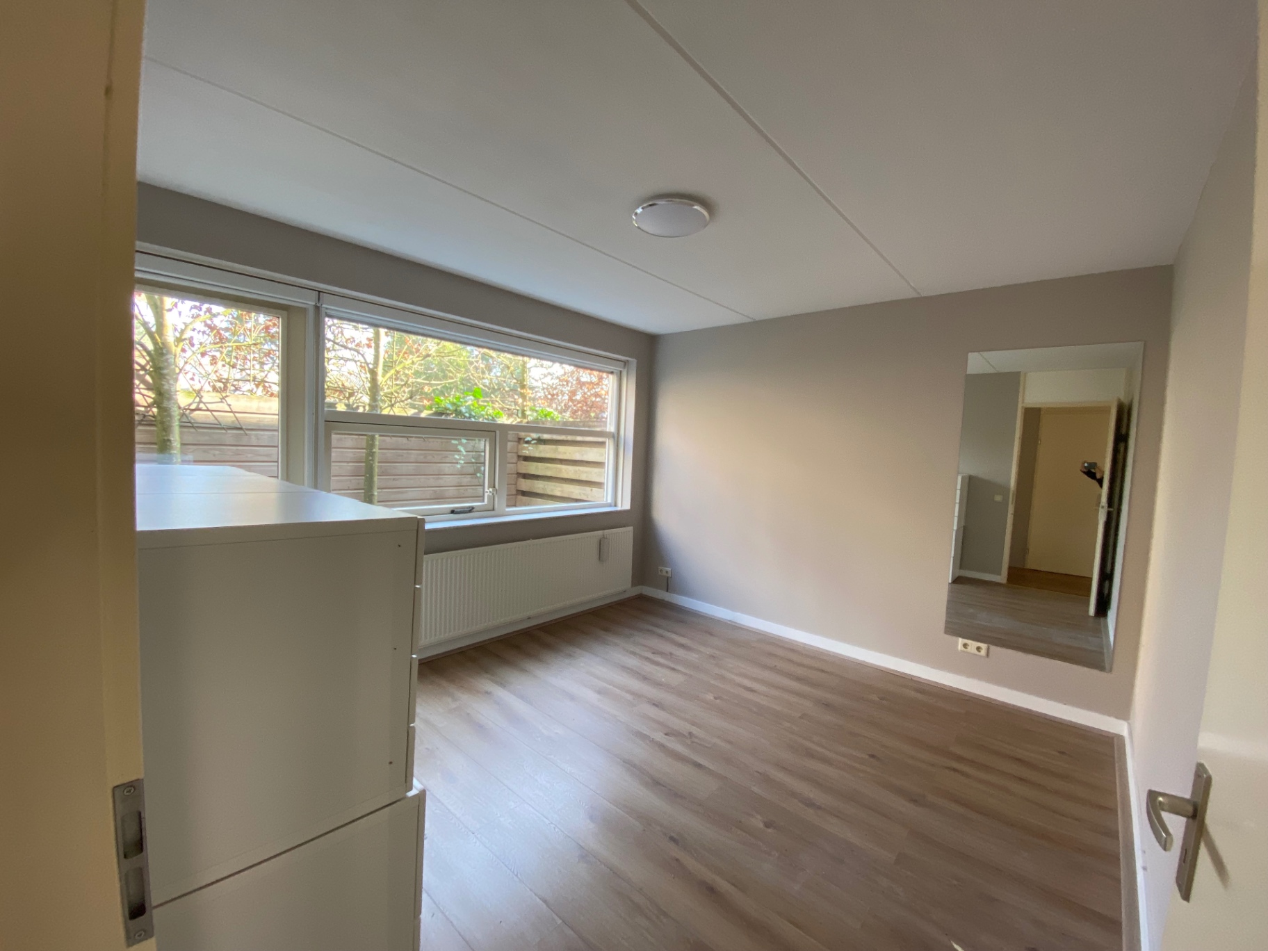 Slaapkamer met raam naar de tuin